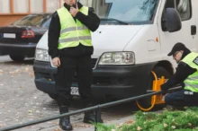 strážníci nasazují na kolo auta botičku