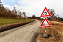 Varovné značky u klikaté silnice na venkově