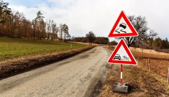 Varovné značky u klikaté silnice na venkově
