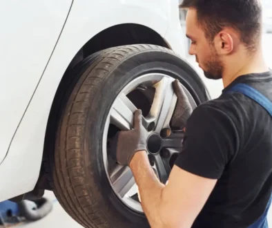 Automechanik nasazuje kolo na vůz v autoservisu