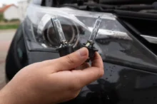 Muž drží v ruce žárovky