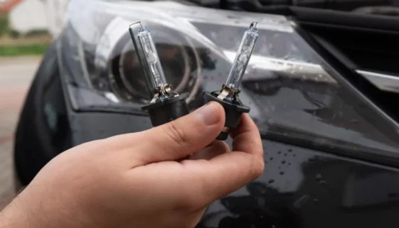 Muž drží v ruce žárovky