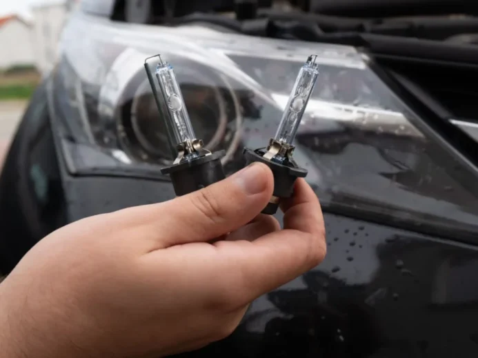 Muž drží v ruce žárovky