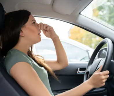 Žena se drží za nos v autě