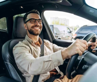 muž s brýlemi řídí auto