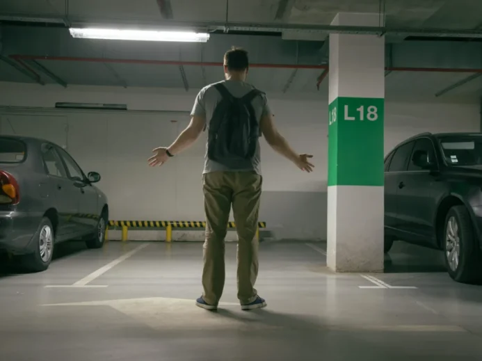 muž hledá vozidlo na parkovišti