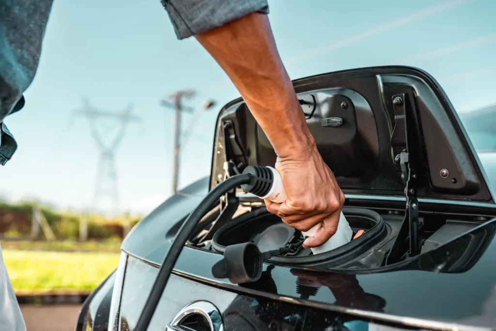 Muž nabíjí elektromobil