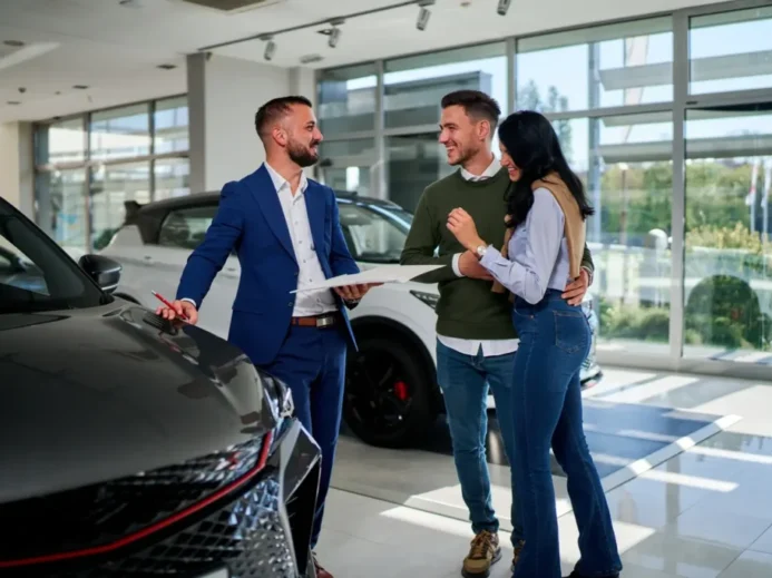 mladý pár a prodavač při koupi auta