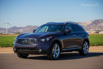 Maroon Infiniti SUV on a rural road with green fields, wind turbine, and distant mountains.